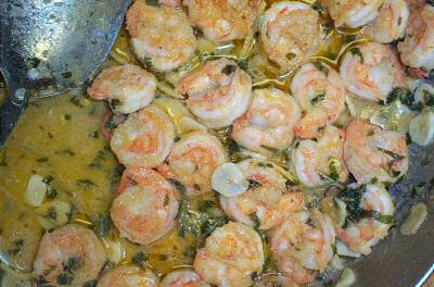Bakken van scampi diabolique in boter en olijfolie met zeer fijngesneden groenten en knoflook