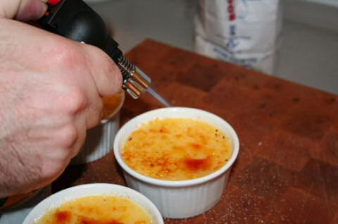 Creme brulee recept: carameliseren van de suiker op de koude pudding met een bunzenbrander