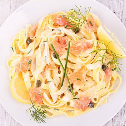 Tagliatelle met gerookte zalm in romige roomsaus met citroen, kappertjes, bieslook en dille.