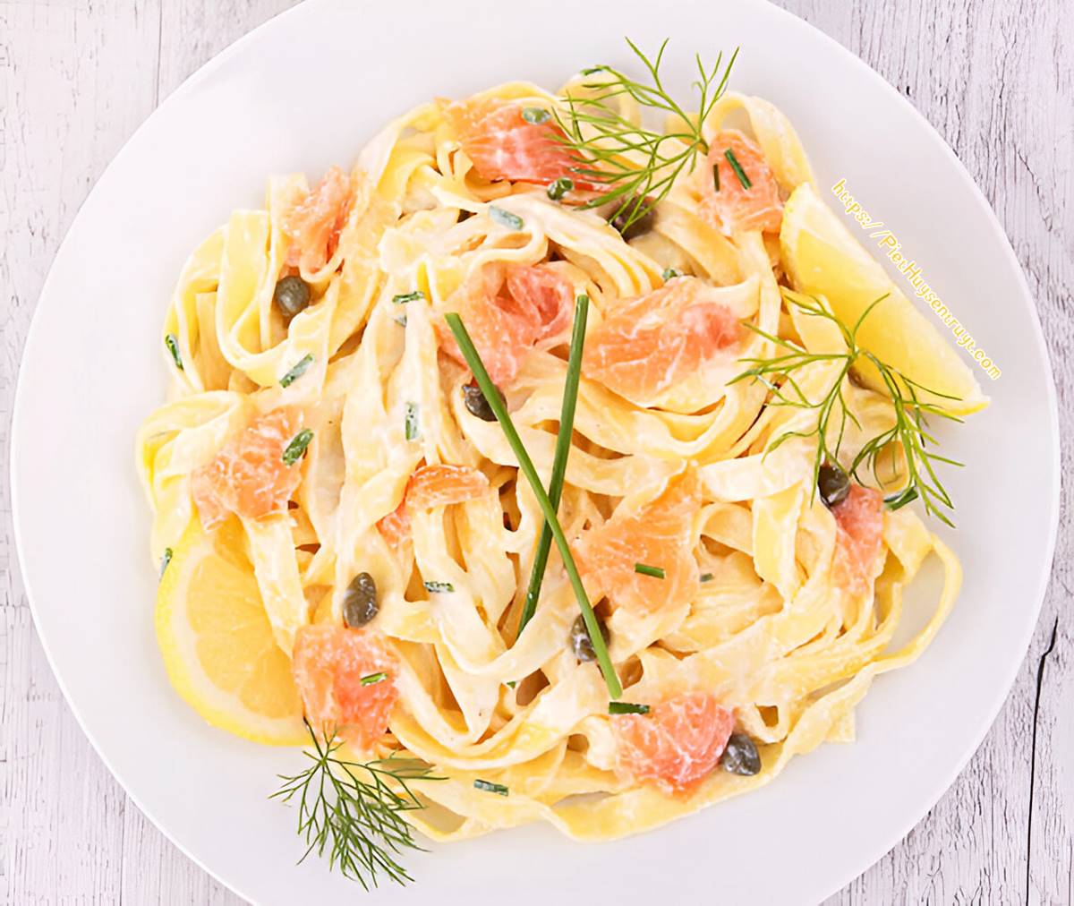 Tagliatelle met gerookte zalm in romige roomsaus met citroen, kappertjes, bieslook en dille.